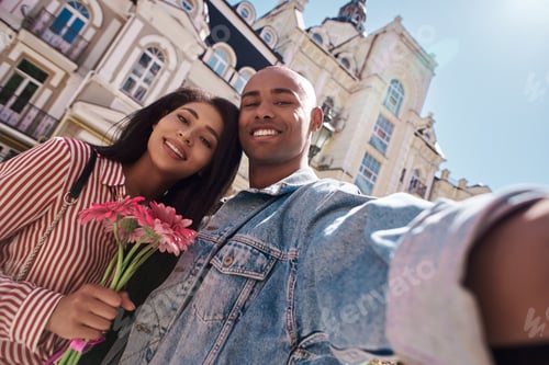 Preview: Romantic Relationship. Young diverse couple walking on the city street girl holding flowers while