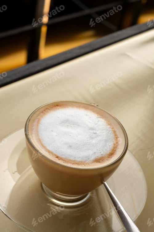 Foamy Cappuccino in Glass Cup on Table