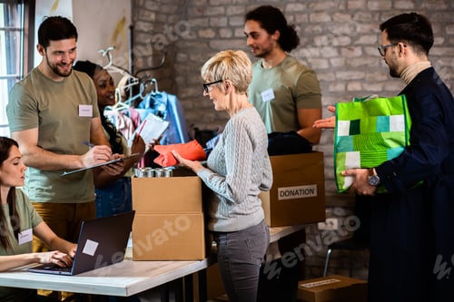 Preview: Group of volunteers with working in community charity donation center.