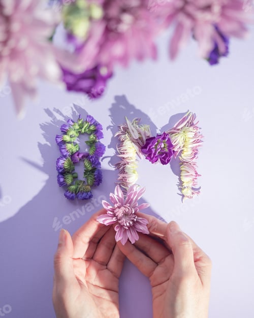 Preview: Hands holding flower near 8m floral typography