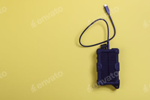 Preview: cheapest source of electricity. power box, portable solar battery for phone on yellow background.