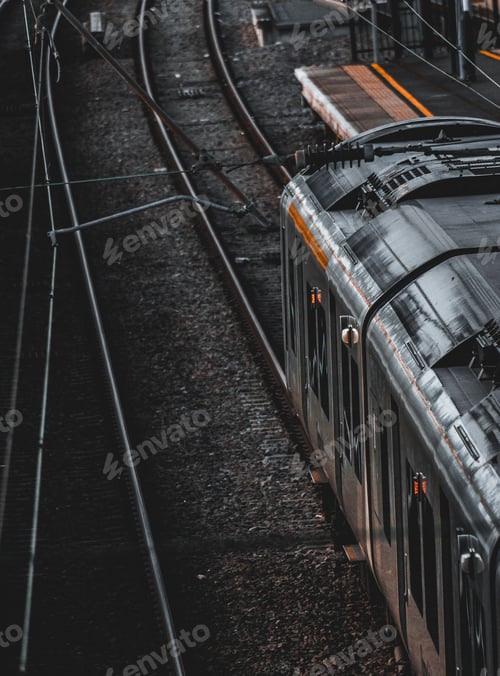 Vista previa: Large old train is pictured traveling down a set of railway tracks in a rural landscape