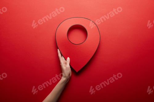 Preview: top view of red handmade geolocation symbol on red background