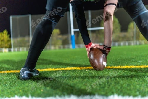 Preview: American football player placing ball on field for kickoff
