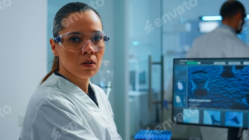 Preview: Lab techinican woman sighing at camera while working at pc