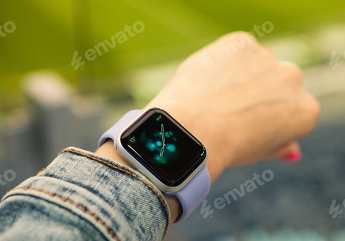 Preview: Young girl look at the time on her smart watch.