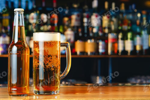 Preview: Beer glass and bottle on wooden countertop in a pub