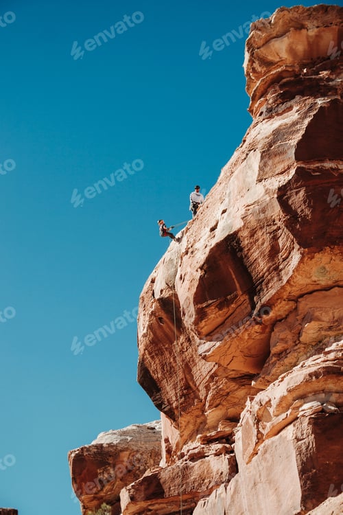 Preview: kid learning to repel off red rock cliff