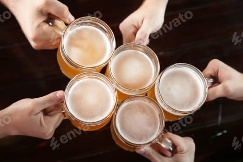 Preview: Friends clinking glasses with beer in pub