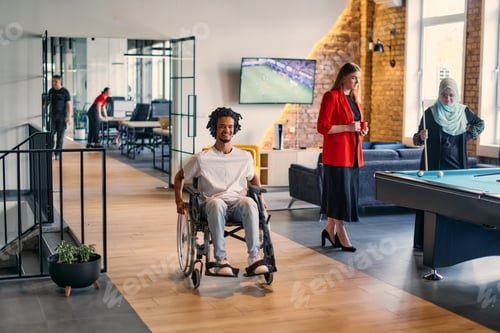 Preview: An African-American young entrepreneur in a wheelchair is surrounded by his business colleagues in a
