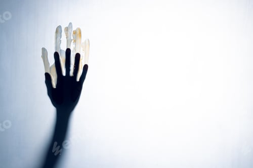 Preview: Composition of shape of black hand with blood stains on white background
