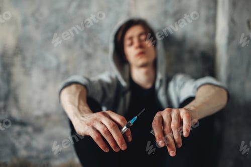 Preview: Druggy with syringe in hand sitting on the floor