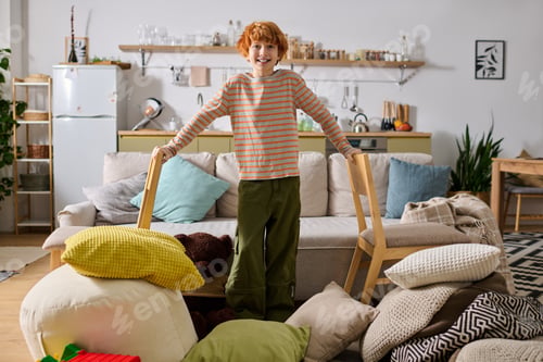 Preview: Little boy joyfully plays in a cozy living room filled with colorful cushions and excitement