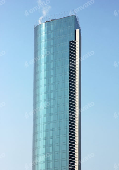 Preview: High-rise building with blue glass facade against the blue sky. Multi-storey office building.