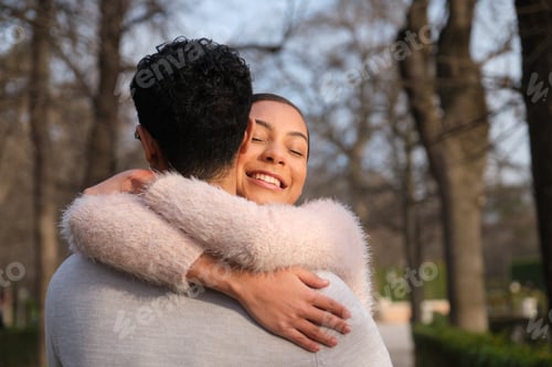 Preview: Happy couple embracing each other in a park during sunset