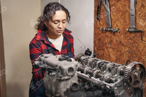 Preview: Woman auto mechanic fixing car engine at service station