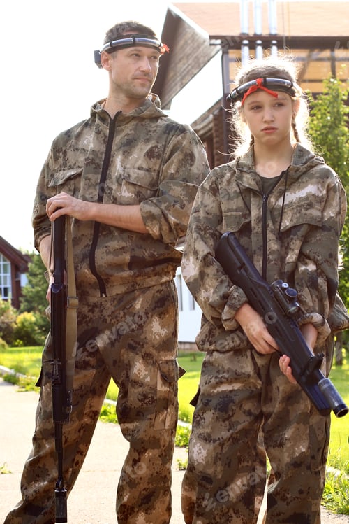 Preview: Father and Teenager in Camouflage with Toy Guns