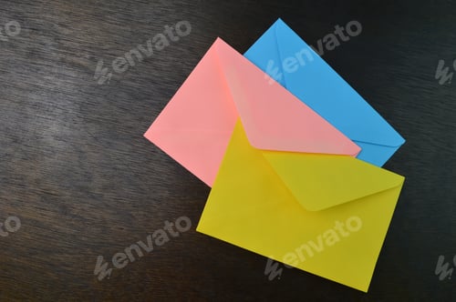Preview: Top view of yellow, orange and blue envelopes on the table