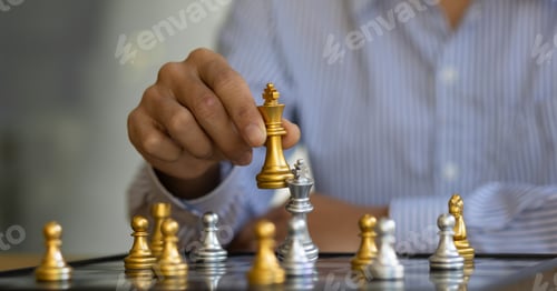 Preview: Businessman moving gold Chess King figure and Checkmate opponent during chessboard competition.