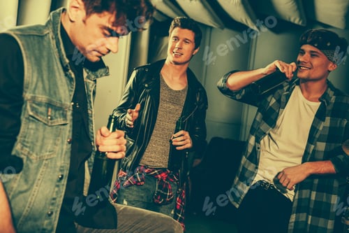 Preview: selective focus of handsome men holding bottles with beer while looking at friend