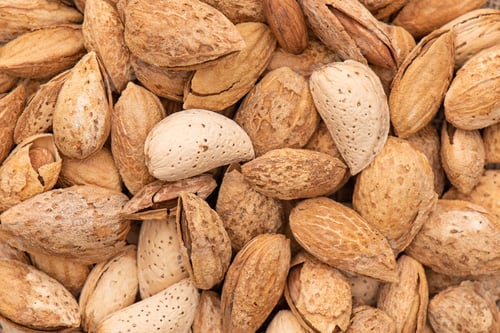 Preview: Heap of almonds in a nutshell macro shot.