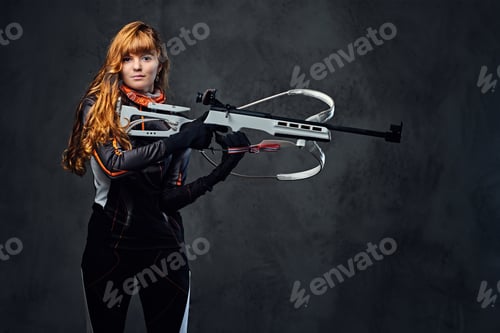 Preview: Redhead female Biathlon champion aiming with a competitive gun.