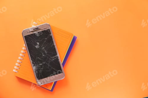 Preview: Top view of broken smart phone on color background