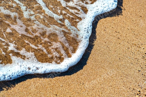 Preview: Close up of small sea waves with clear blue water over yellow sand beach at summer sunny shore