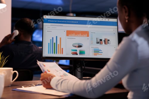 Preview: Office employee analyzing business charts on computer