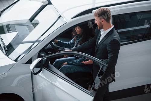 Preview: Female customer and modern stylish bearded businessman in the automobile saloon