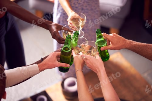 Preview: Close Up Of Friends In Lounge At Home Making A Toast With Beer And Wine
