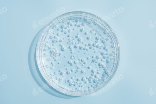 Visualização: Gotas transparentes de gel de soro de produto cosmético em placa de Petri. Textura líquida com bolhas