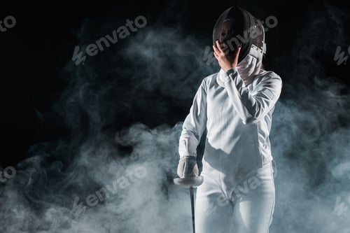 Preview: Fencer holding fencing mask and rapier on black background with smoke