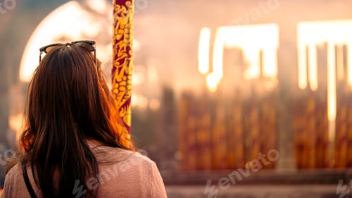 Preview: Woman observing incense altar at Taiwanese temple in Taichung during sunset
