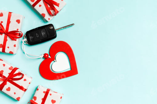 Preview: Top view of car key, gift boxes and wooden heart on colorful background.