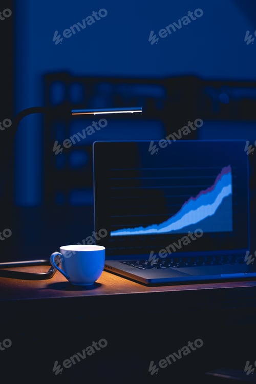 Preview: Computer in a dark room with graphs on the screen.