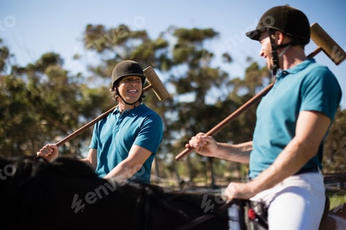 Preview: Two male jockeys riding horse in the ranch