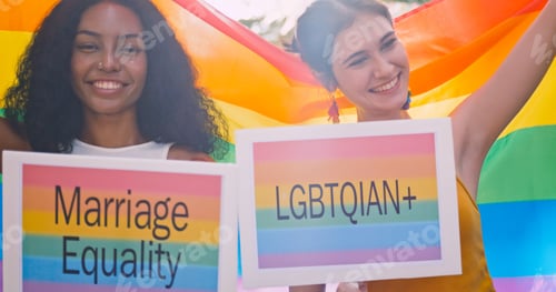 Preview: A lesbian couple waves a rainbow flag, a symbol of homosexuality, during a pride parade.