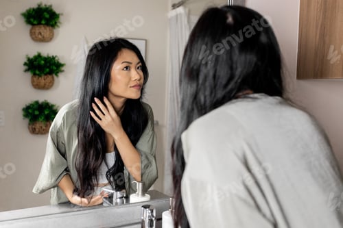 Preview: Woman Styling Hair in Bathroom Mirror