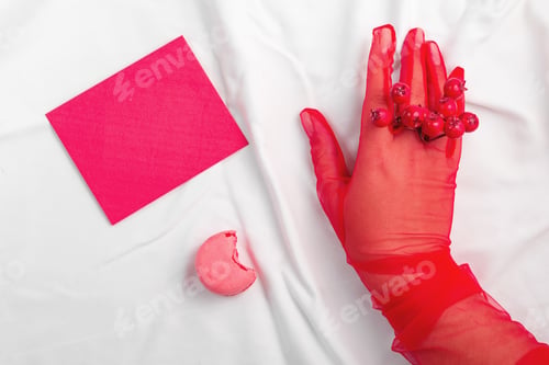 Preview: Pink macaron with a woman hand in vintage gloves and mockup letter on white textile