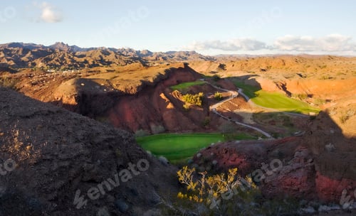 Preview: An elevated view over the mountain and desert landscape and golf course greens in the valley.