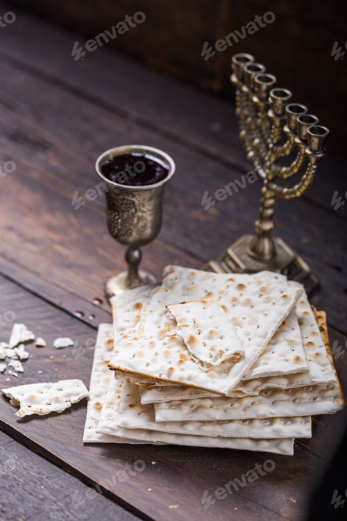 Preview: Red kosher wine with a white matzah or matza on a vintage wood background presented as a Passover