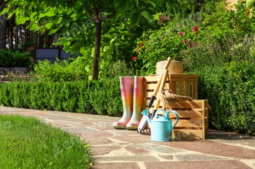 Preview: Wooden crates and gardening tools on stone path at backyard