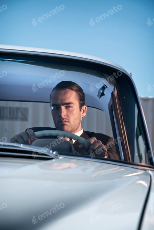 Preview: Retro 60S Fashion Business Man Wearing Grey Suit With Tie Sitting In Classic Car.