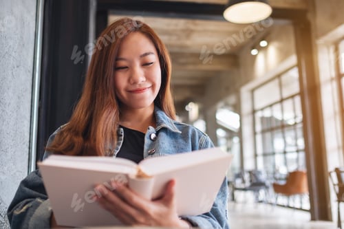Preview: Portrait image of a young beautiful asian woman sitting and reading book