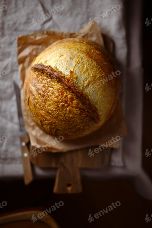 Preview: Top view on crusty sourdough bread with cracked crust