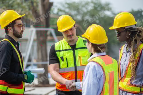 Preview: Engineering and foreman shaking hands on construction site and Agree. partnership and connection.