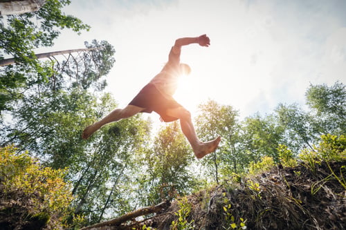 Preview: Young man jumping in the forest.