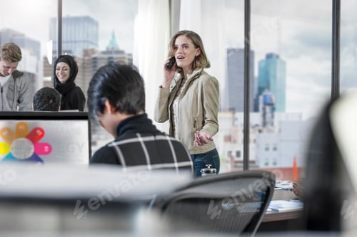 Preview: Woman on the phone in busy office
