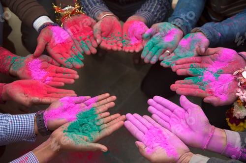 Preview: People standing in circle, holding up palms painted green adn pink